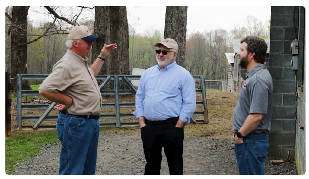 Three men talking on a farm